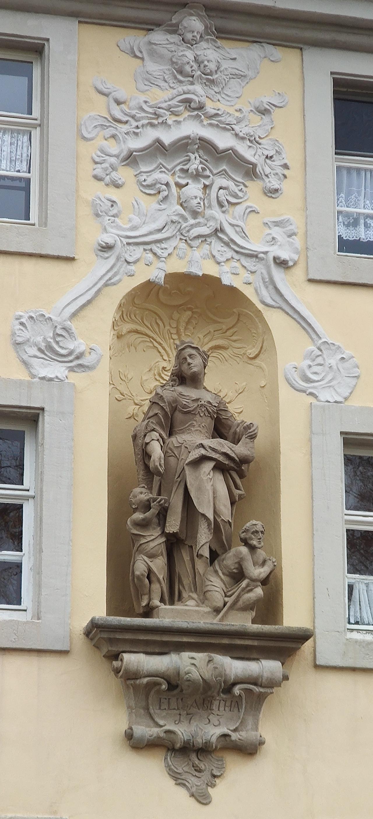 Die Steinfigur der Hl. Elisabeth an der Fasade des Spitals